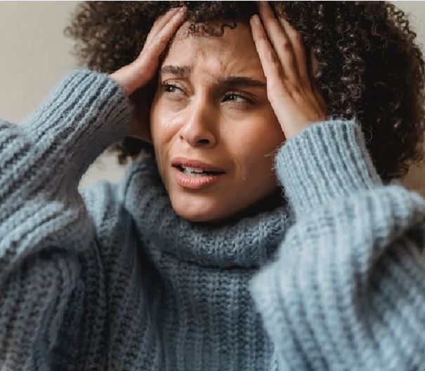 You Are Not Your Thoughts. The 4 Stages To Dealing With Your Thoughts. Picture of a woman looking troubled and holding her head.