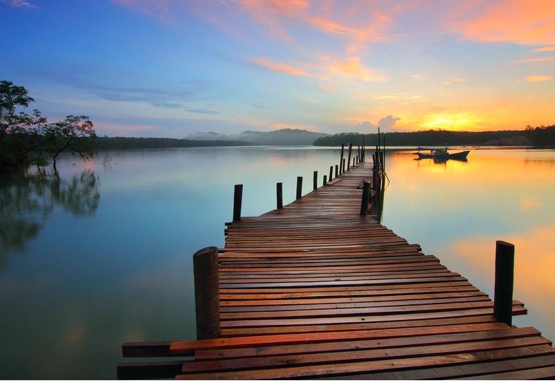 What Is My Life Purpose? What Is The Meaning Of Life? Photo of a wooden jetty leading out towards a sunset on a lake.