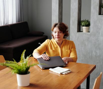 Finish What You Start. Action Will Destroy Your Procrastination. 4 Key Tips To Help You Finish What You Start. Picture of woman closing her laptop having completed a task.