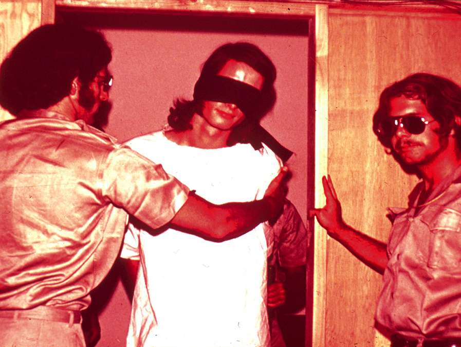 Stanford Prison Experiment. A Masterclass In Self Deception. Yes You Can Fool Most Of The People For Over 30 Years. Photo of students involved playing at guards and prisoners.