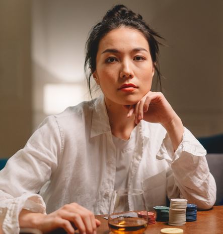 The Luck Factor - 4 Basic Principles. Picture of an Asian woman gambling in a casino.